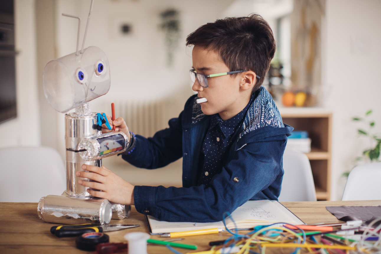 Boy making robot toy for school project